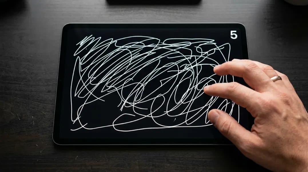 Touchscreen test interface showing a dark canvas on a tablet display with multiple colored line traces drawn by finger across the full screen area, a small dead zone visible in the lower left corner where the line trace has a gap, and a multitouch counter in the top right showing the number 5 indicating five simultaneous touches detected Touchscreen test interface showing a dark canvas on a tablet display with multiple colored line traces drawn by finger across the full screen area, a small dead zone visible in the lower left corner where the line trace has a gap, and a multitouch counter in the top right showing the number 5 indicating five simultaneous touches detected